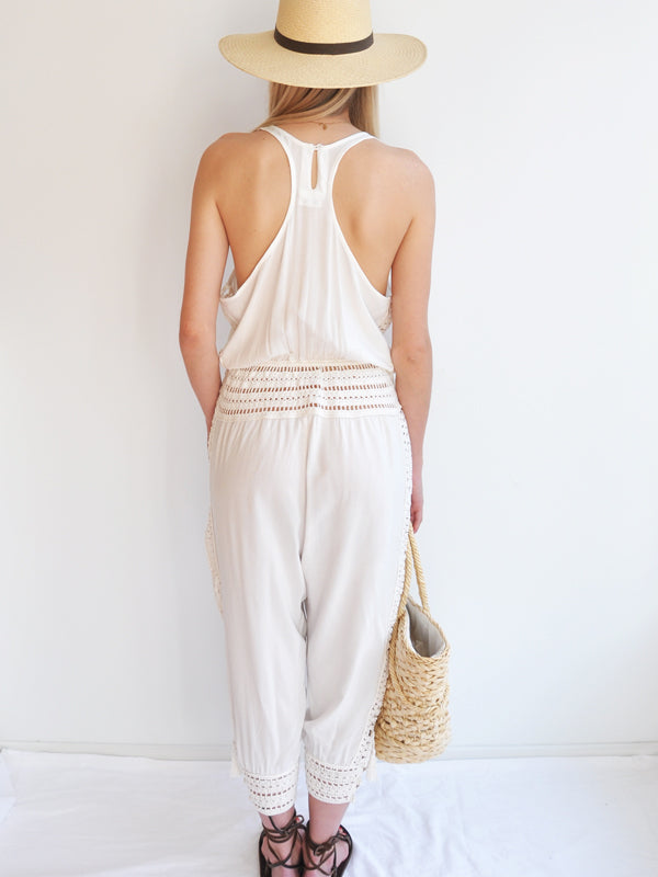 Anna Kosturova Relaxed fit romper with handmade crochet inserts at the waist and as the leg cuffs with incased button closure, embellished with tassels. Unique and comfortable festival look.